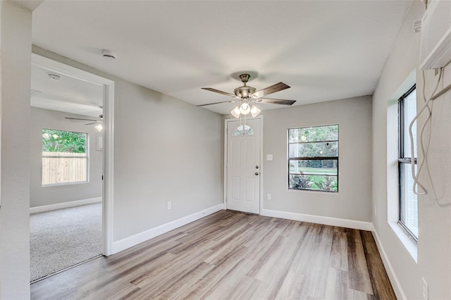 spare room featuring light wood-type flooring, a healthy amount of sunlight, and ceiling fan