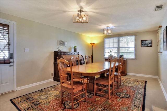 dining room featuring baseboards, visible vents, and a chandelier