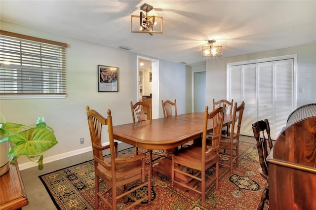 dining area featuring visible vents, baseboards, and a chandelier