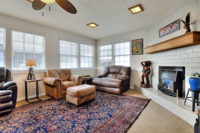 living area featuring carpet flooring, a fireplace, baseboards, and ceiling fan