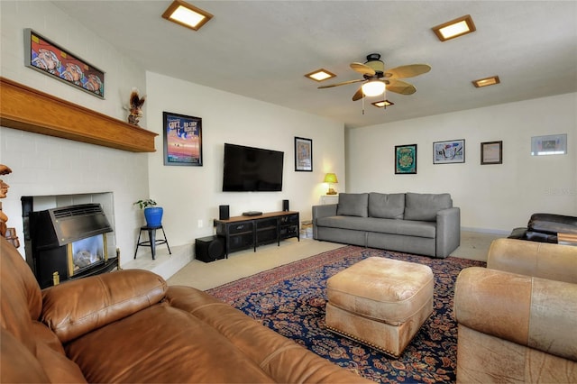 living room featuring a brick fireplace, light carpet, ceiling fan, and baseboards