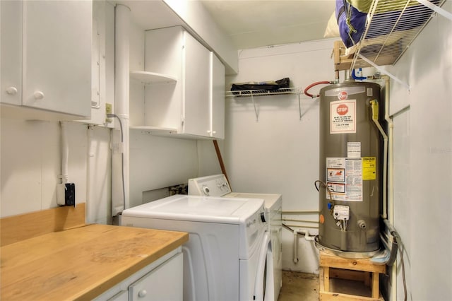 clothes washing area featuring cabinet space, gas water heater, and washing machine and clothes dryer