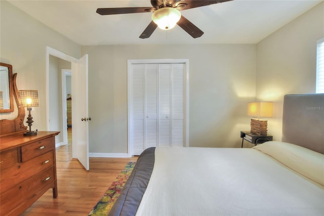 bedroom with light wood-style floors, baseboards, a ceiling fan, and a closet