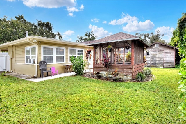 view of front facade featuring a shed, a front yard, cooling unit, and an outdoor structure