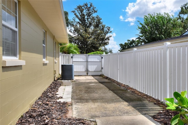 view of yard with cooling unit, a fenced backyard, and a gate