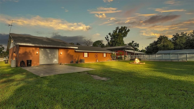 back house at dusk with a yard and a patio area