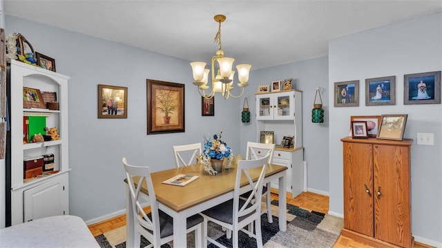 dining room featuring light parquet floors and a notable chandelier