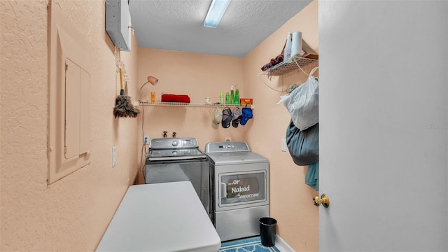 washroom with a textured ceiling and separate washer and dryer