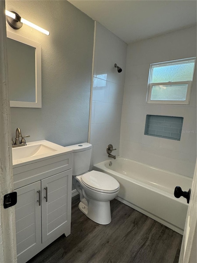 full bathroom featuring vanity, toilet, tiled shower / bath combo, and hardwood / wood-style floors