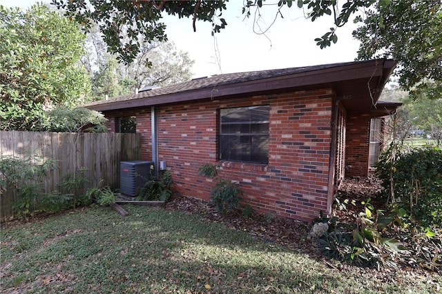 view of property exterior featuring central AC and a lawn