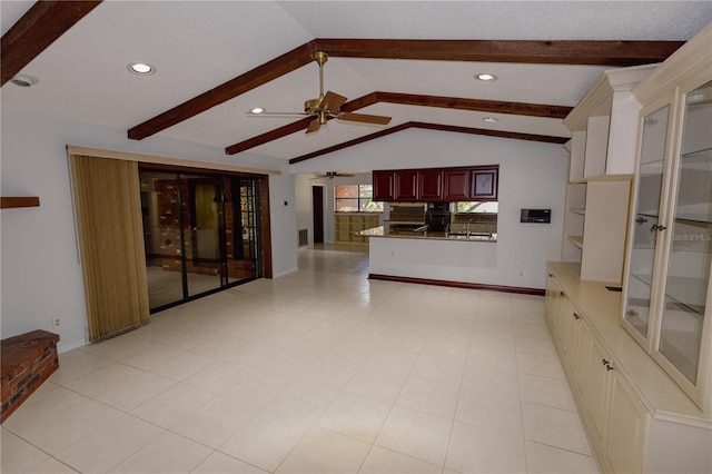 unfurnished living room featuring ceiling fan, sink, and vaulted ceiling with beams