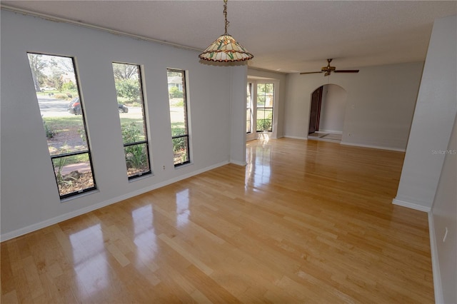 empty room with a textured ceiling and light hardwood / wood-style flooring