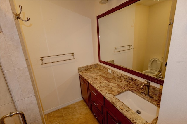 bathroom with toilet, vanity, and tile patterned flooring