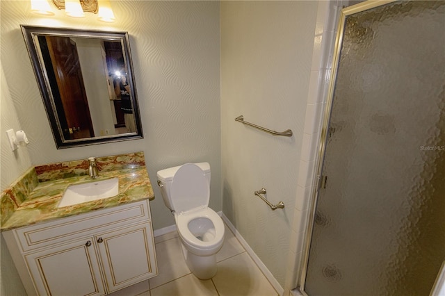 bathroom featuring tile patterned floors, toilet, vanity, and a shower with shower door