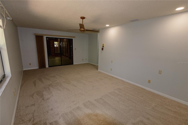 unfurnished room featuring ceiling fan, light carpet, and a textured ceiling