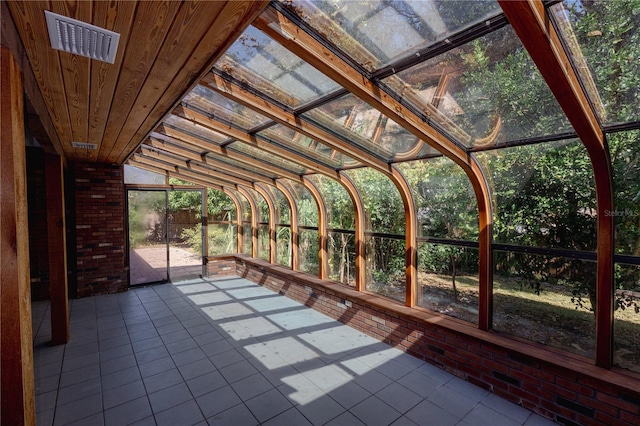 unfurnished sunroom featuring vaulted ceiling and wooden ceiling