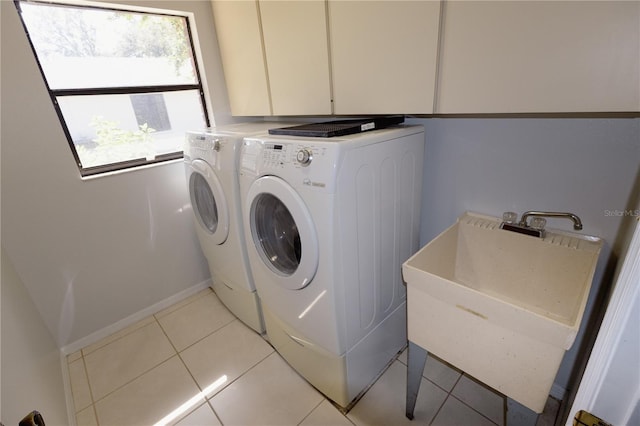 laundry area with sink, cabinets, separate washer and dryer, and light tile patterned floors