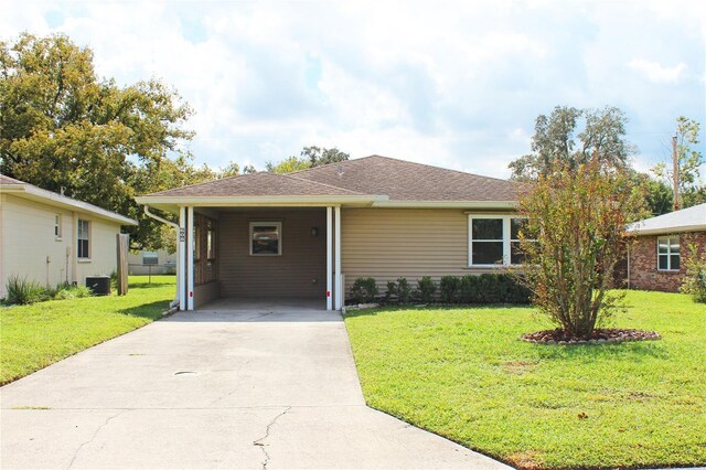 ranch-style home with central air condition unit, a carport, driveway, and a front lawn
