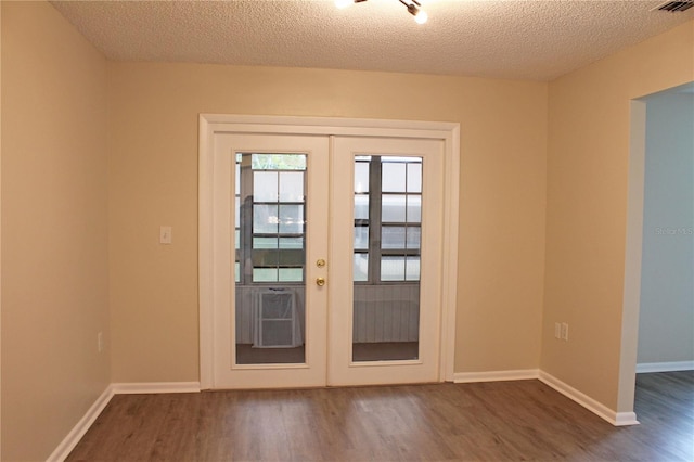 entryway featuring french doors, dark hardwood / wood-style floors, and a textured ceiling