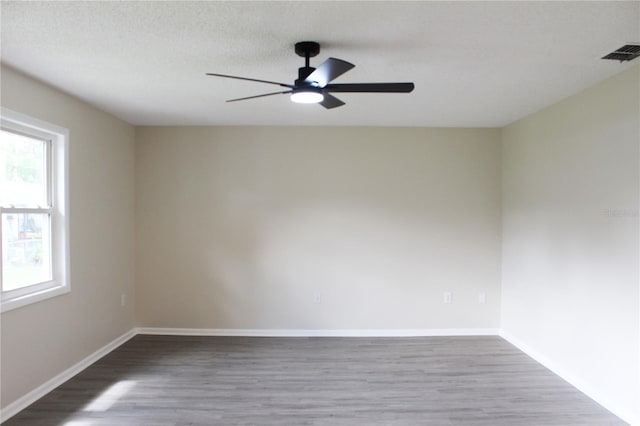 spare room with ceiling fan, hardwood / wood-style flooring, and a textured ceiling