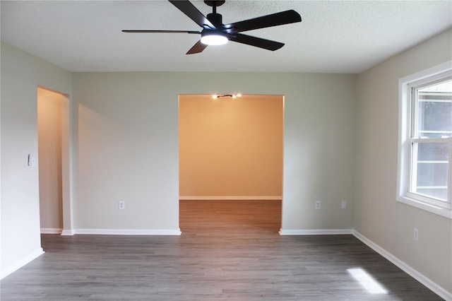 empty room with ceiling fan, hardwood / wood-style flooring, and a textured ceiling