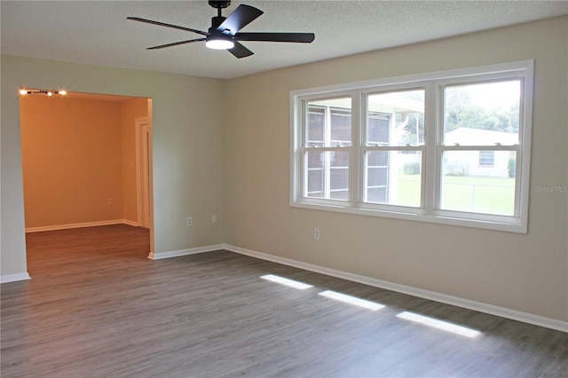 empty room with ceiling fan, hardwood / wood-style flooring, and a textured ceiling