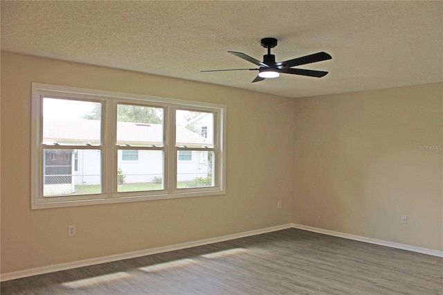 empty room with a textured ceiling, wood-type flooring, and ceiling fan