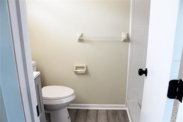 bathroom with toilet, hardwood / wood-style floors, vanity, and a shower