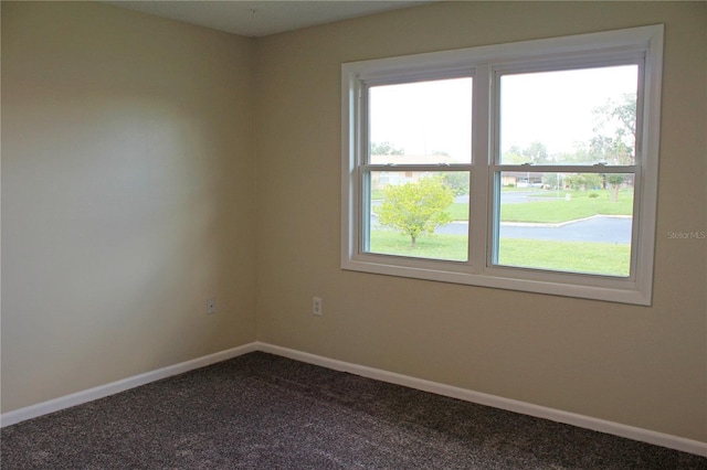 carpeted empty room featuring baseboards