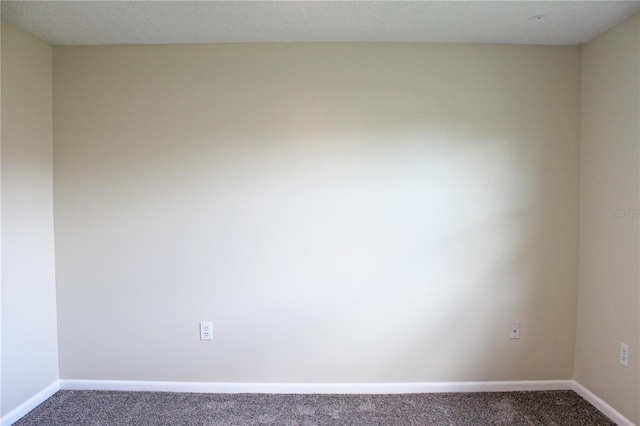 unfurnished room with baseboards and carpet