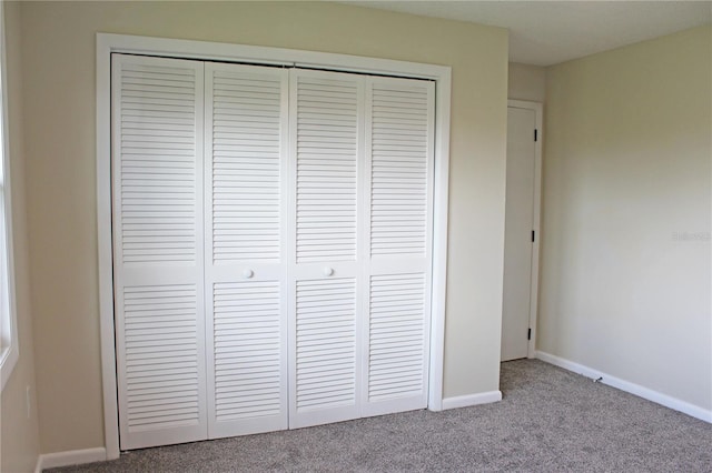 unfurnished bedroom featuring a closet and light carpet