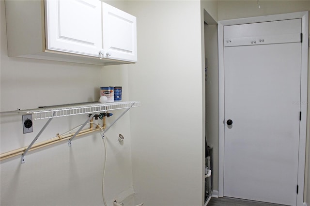 laundry area featuring hookup for a washing machine, electric dryer hookup, wood-type flooring, and cabinets