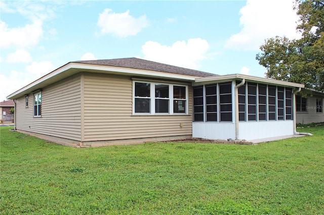 back of property featuring a lawn and a sunroom