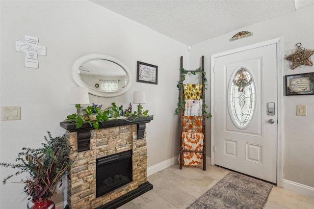 foyer featuring a stone fireplace and a textured ceiling