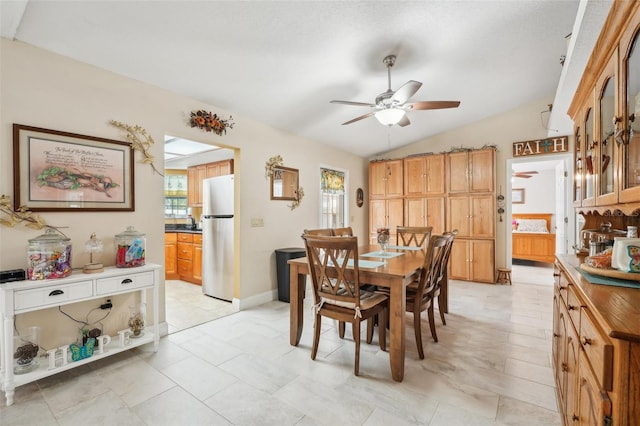 dining area featuring ceiling fan, light tile patterned flooring, and lofted ceiling