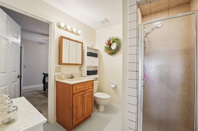 bathroom with a shower with door, vanity, and toilet