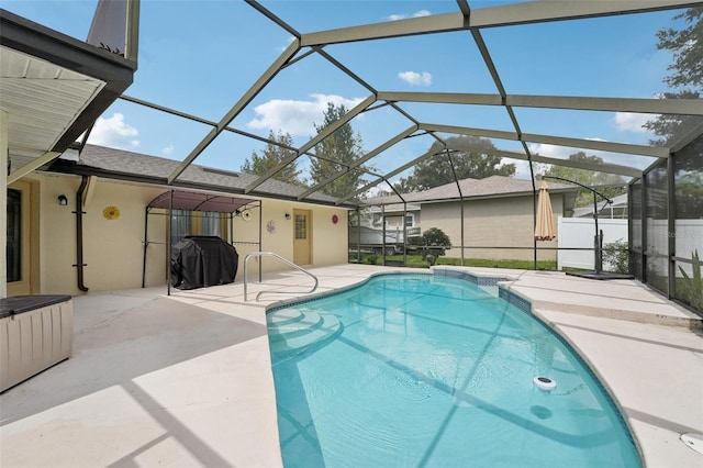 view of pool with a patio and glass enclosure