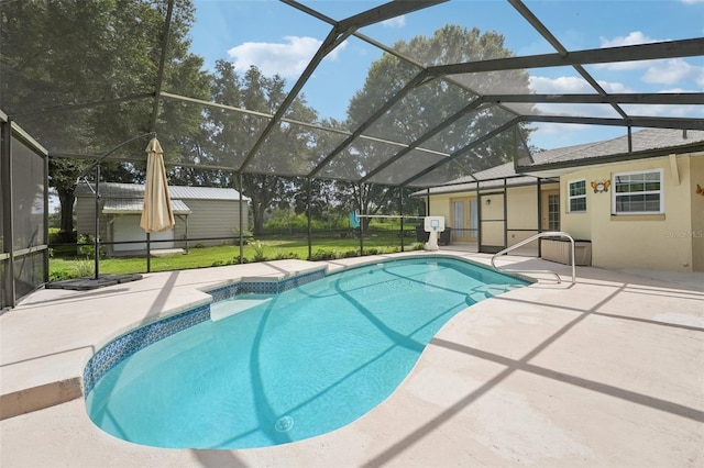 view of swimming pool featuring a lanai, a patio area, and a shed