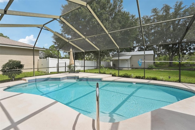 view of pool with a lawn, glass enclosure, and an outbuilding