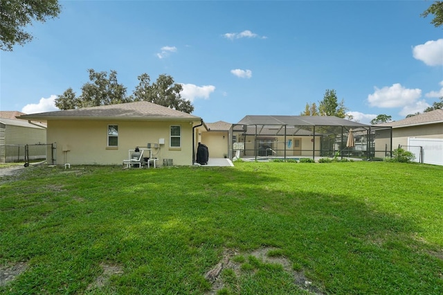 back of property featuring a lanai and a yard