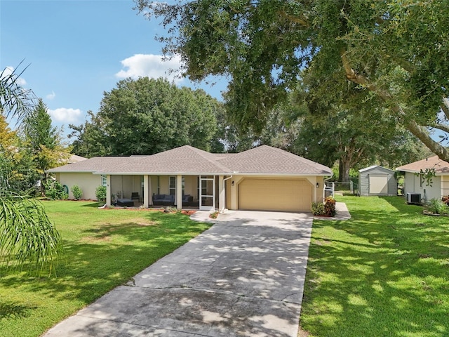 single story home featuring a front lawn, covered porch, central AC unit, and a garage