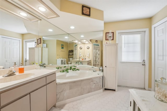 bathroom featuring tile patterned floors, vanity, and tiled tub