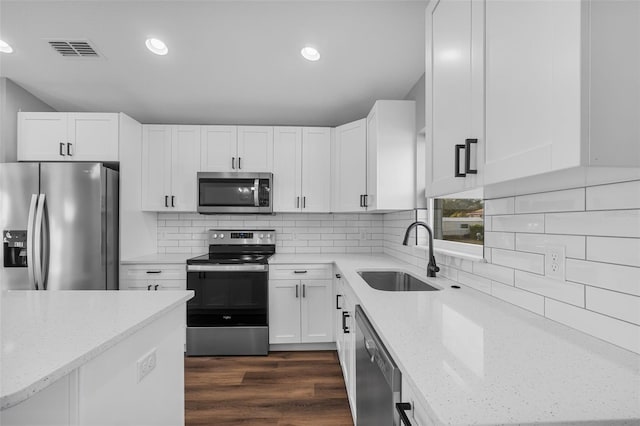 kitchen with white cabinets, light stone counters, sink, and stainless steel appliances