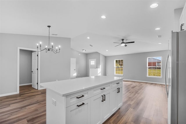 kitchen with white cabinets, a center island, stainless steel fridge, and dark hardwood / wood-style flooring