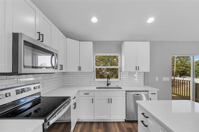 kitchen featuring decorative backsplash, stainless steel appliances, dark wood-type flooring, sink, and white cabinetry