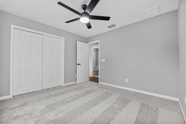 unfurnished bedroom featuring a closet, light colored carpet, and ceiling fan