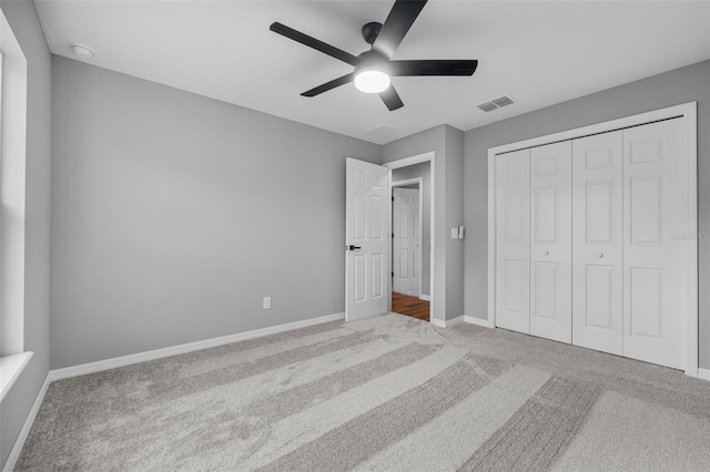 unfurnished bedroom with ceiling fan, a closet, and carpet