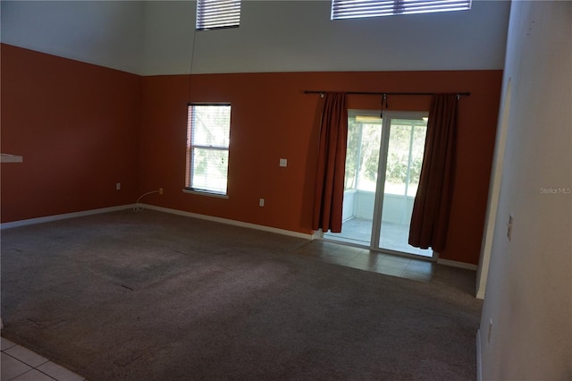 empty room featuring a high ceiling and light colored carpet