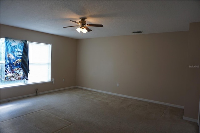 empty room with a textured ceiling, carpet, and ceiling fan