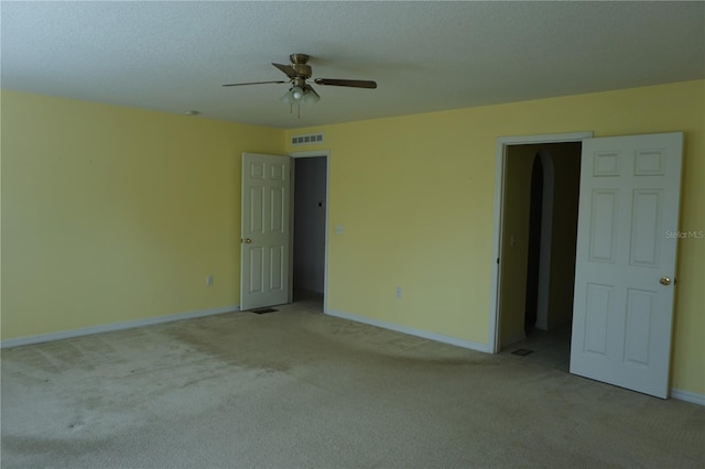 carpeted empty room featuring a textured ceiling and ceiling fan